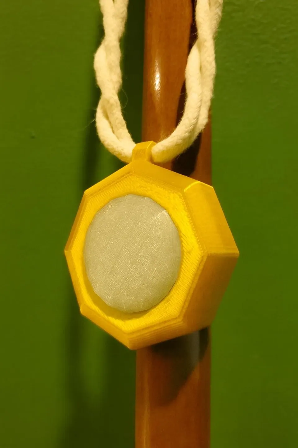 Amulet of power with a pale diamond, hanging from a braided cord