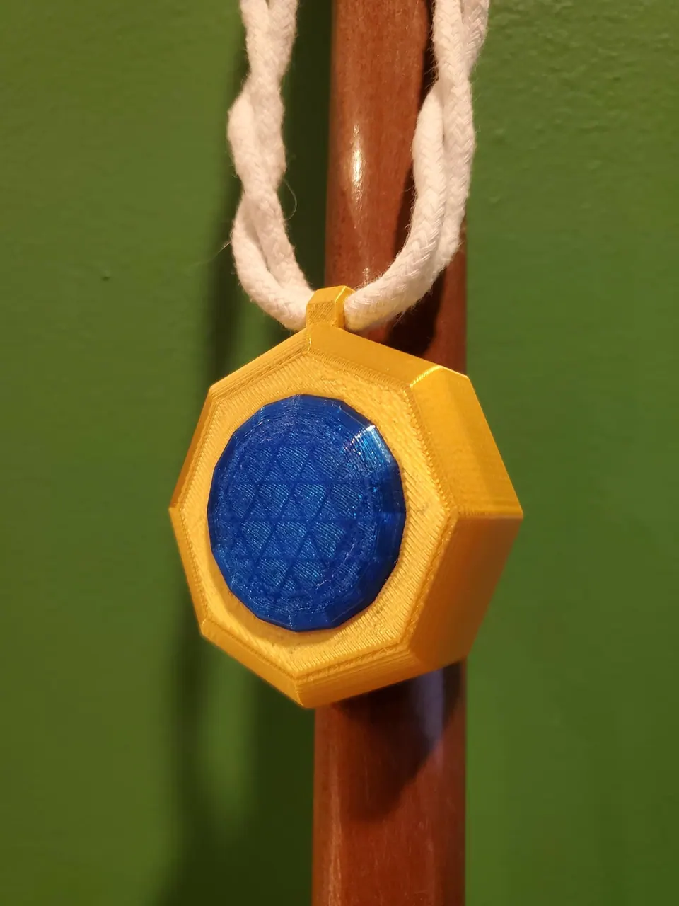 Amulet of magic with a blue sapphire, hanging from a braided cord